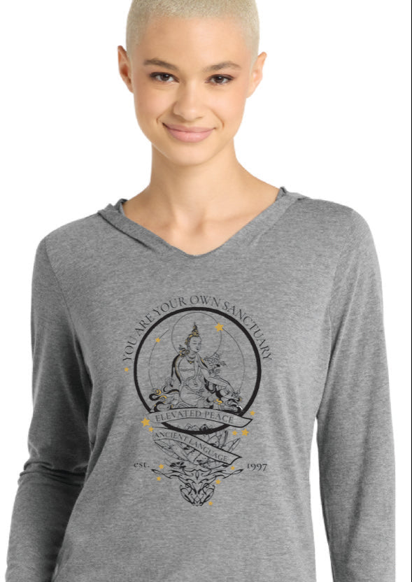 Woman wearing a gray long-sleeve shirt with a graphic design on a white background